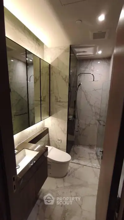Luxurious marble bathroom with modern fixtures and glass shower enclosure