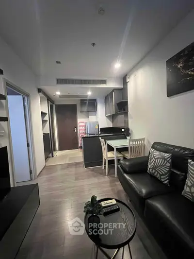 Modern open-layout living room with sleek kitchen and stylish decor in a contemporary apartment.