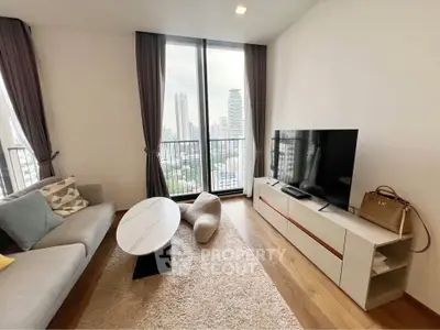 Modern living room with large windows and city view, featuring stylish furniture and decor.
