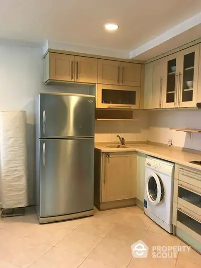 Modern kitchen with stainless steel fridge and washing machine