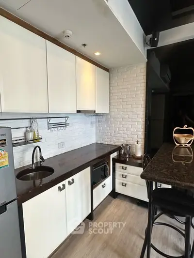 Modern kitchen with sleek design, featuring dark countertops and white cabinetry, perfect for urban living.