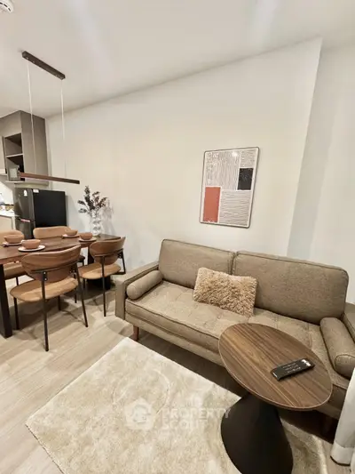 Modern living room with cozy sofa and dining area in open layout apartment.