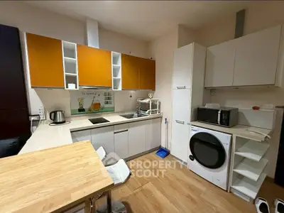 Modern kitchen with sleek cabinets, built-in appliances, and wooden flooring