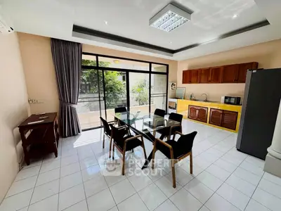 Spacious kitchen with open layout and modern dining area, featuring large windows and ample natural light.