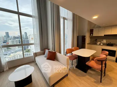 Modern living room with city view, featuring elegant furniture and open kitchen layout.