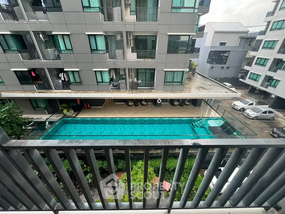 Modern apartment building with a pool view from balcony, showcasing urban living amenities.