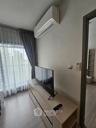 Modern living room with air conditioning and city view, featuring sleek furniture and natural light.