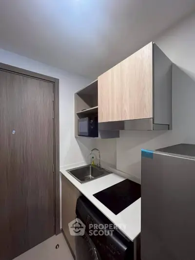 Modern compact kitchen with sleek cabinetry and integrated appliances