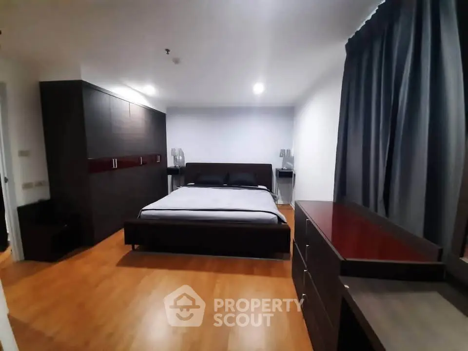 Spacious modern bedroom with sleek furniture and wooden flooring