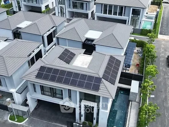 Modern residential complex with solar panels and private pool, showcasing sustainable living.