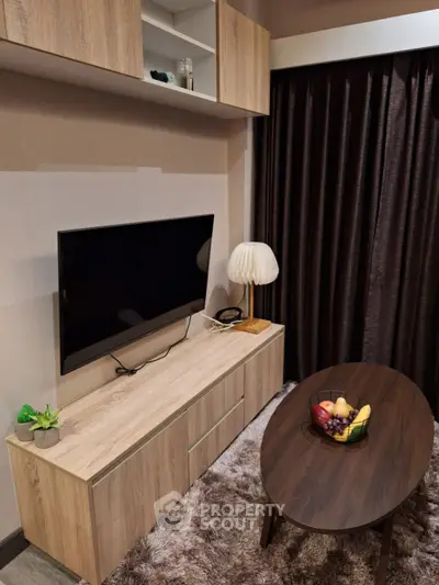 Cozy living room with modern TV setup and stylish wooden furniture.