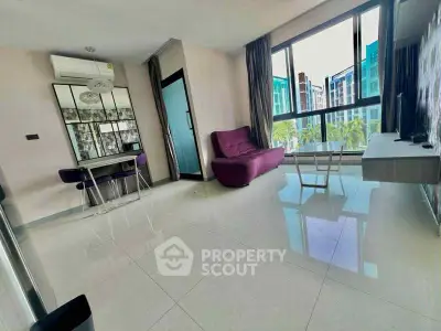 Modern living room with large windows and stylish furniture in a high-rise apartment.