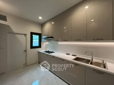 Sleek modern kitchen with glossy cabinets and gas stove