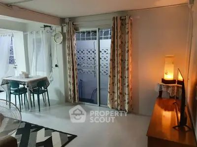 Cozy living room with modern decor and natural light, featuring a dining area and stylish curtains.