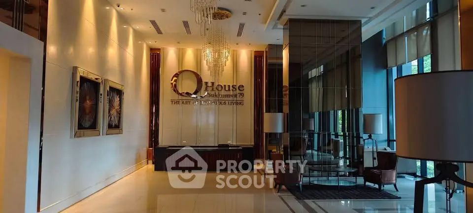 Luxurious lobby with elegant decor and chandelier at Q House, showcasing modern living.