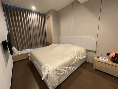 Modern bedroom with elegant design, featuring a cozy bed, stylish curtains, and wooden flooring.