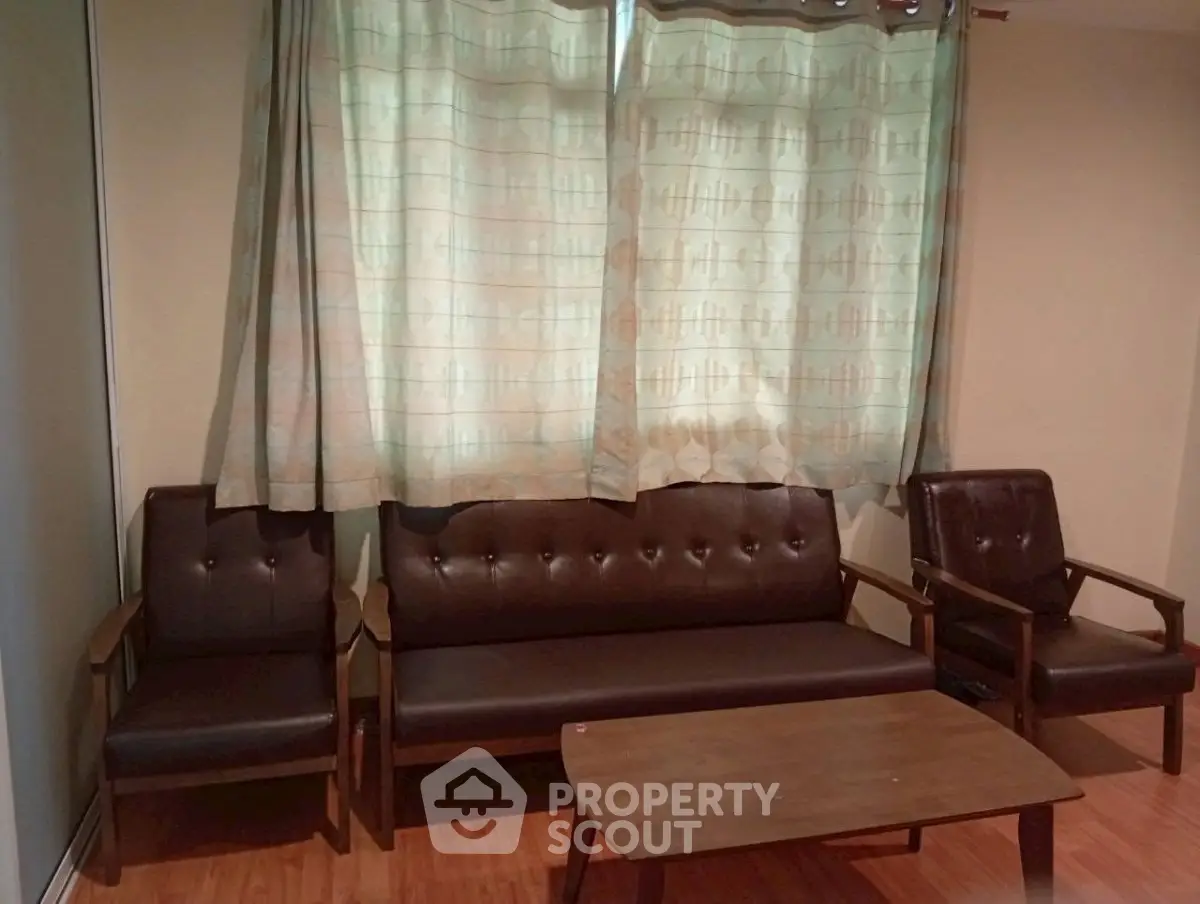 Cozy living room with vintage brown leather sofa set and wooden coffee table, perfect for relaxation.