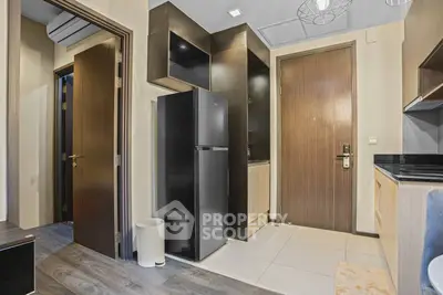 Modern apartment kitchen with sleek black fridge and stylish cabinetry
