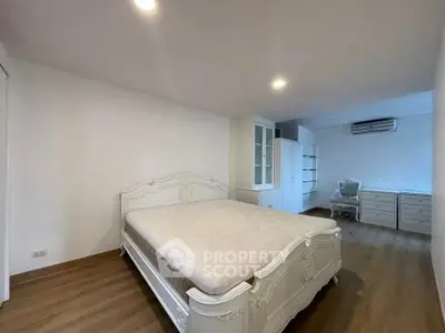 Spacious bedroom with elegant white furniture and ample storage space