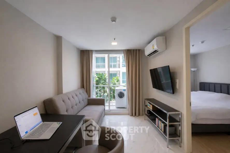 Modern apartment living room with balcony, featuring sleek furniture and natural light.