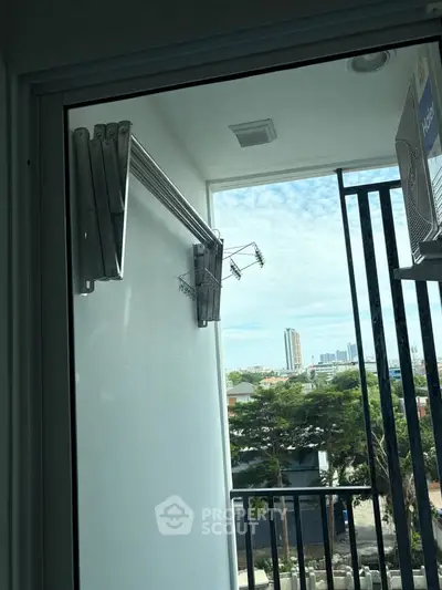 Modern balcony with city view and drying rack, perfect for urban living.