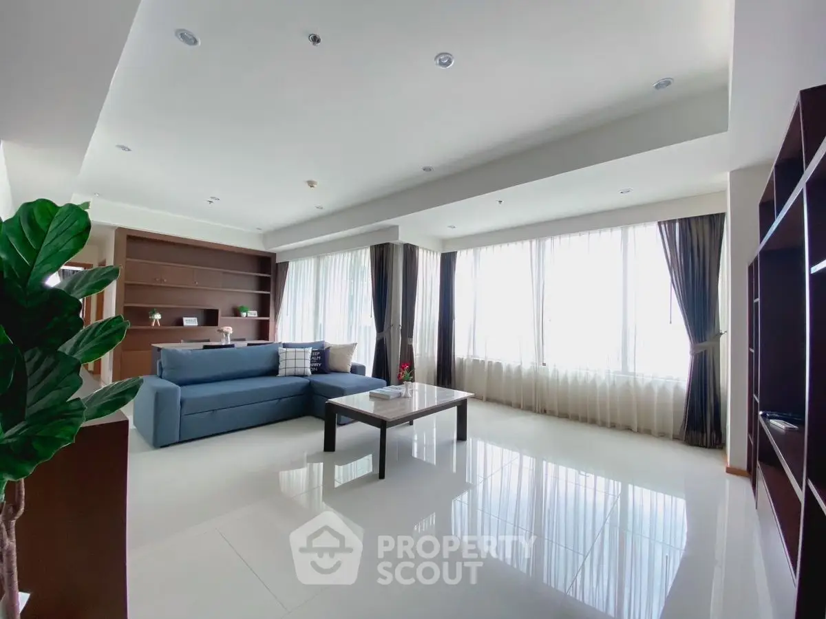 Spacious and bright living room with modern furnishings and large windows.