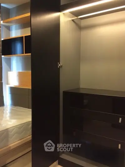 Modern bedroom with sleek black wardrobe and built-in shelves, perfect for stylish storage solutions.