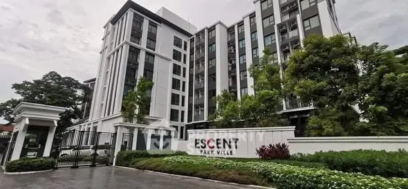Modern residential building with lush greenery at Escent Park Ville entrance.