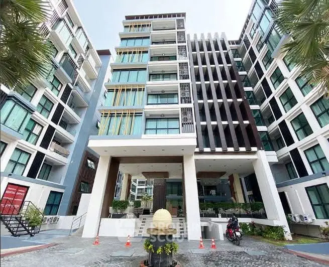 Modern apartment building exterior with contemporary design and lush surroundings.