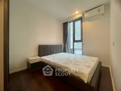 Modern bedroom with large window and air conditioning in a stylish apartment.