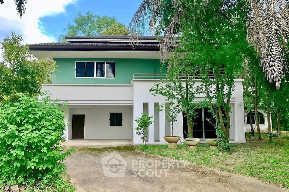 Charming two-story house with lush greenery and spacious driveway