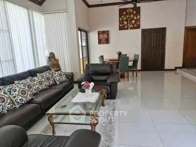 Spacious living room with elegant leather sofas and glass coffee table, perfect for modern living.