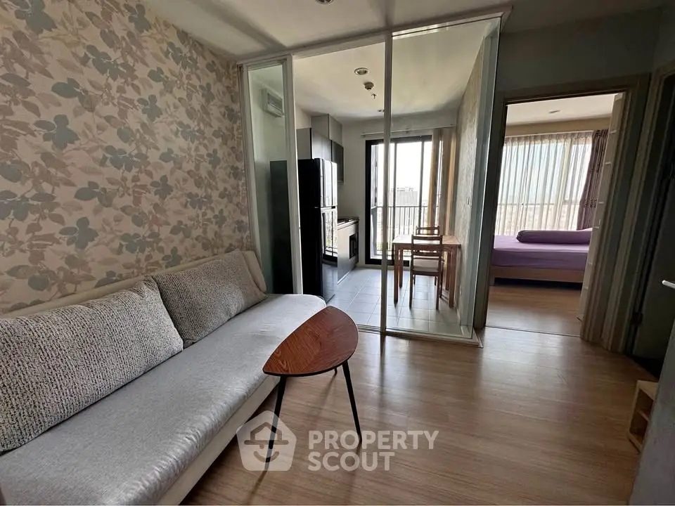 Modern apartment interior with stylish living room and bedroom, featuring floral wallpaper and natural light.