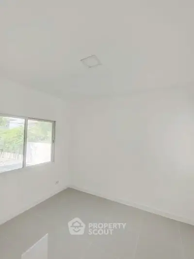 Bright empty room with large window and tiled floor, perfect for customization.