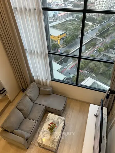 Stunning high-rise living room with floor-to-ceiling windows offering breathtaking city views.