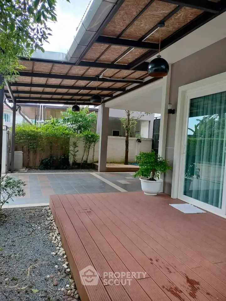 Modern patio with wooden deck and stylish lighting in a serene garden setting.