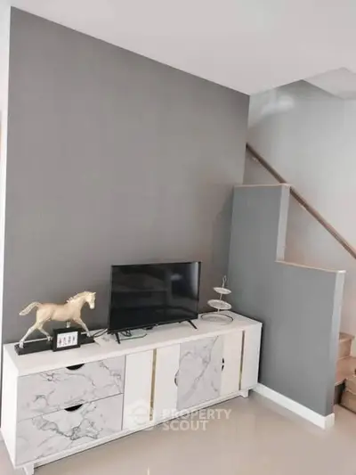 Modern living room with stylish TV stand and staircase