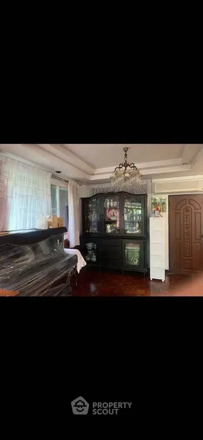 Elegant living room with chandelier and classic wooden furniture, perfect for a cozy home ambiance.