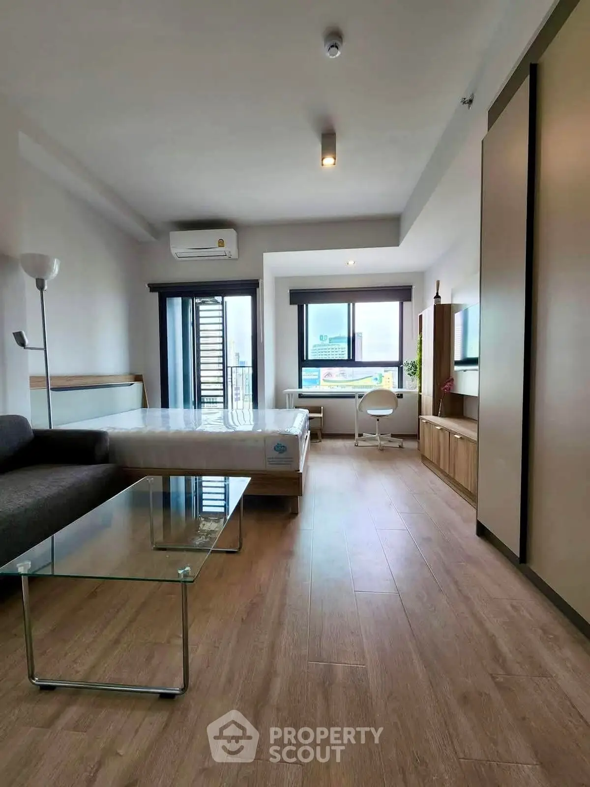 Modern studio apartment with stylish furnishings and large windows for natural light.