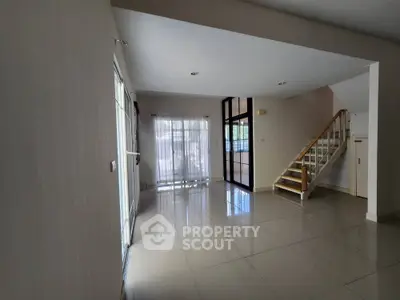 Spacious modern living room with staircase and large windows