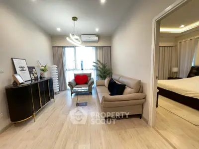 Elegant living room with modern decor and cozy seating next to a stylish bedroom.
