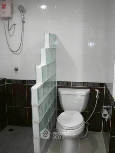 Compact bathroom with glass block partition and modern fixtures