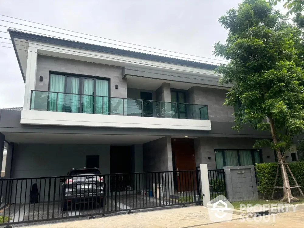 Modern two-story house with sleek design and spacious balcony in a serene neighborhood.