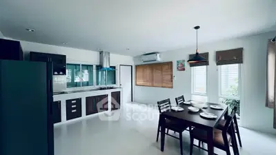 Modern kitchen with dining area, featuring sleek cabinetry and large windows for natural light.