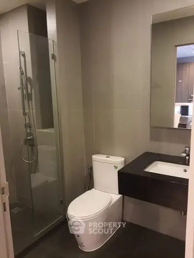 Modern bathroom with sleek design featuring glass shower and contemporary fixtures.