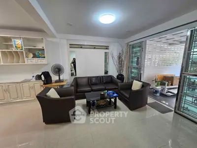 Spacious living room with modern furniture and open layout leading to a covered patio.