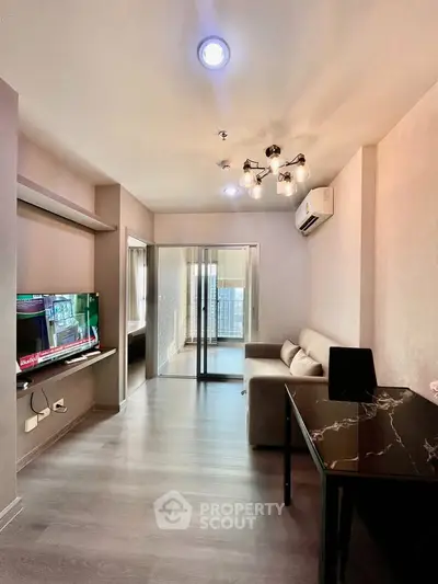 Modern living room with stylish lighting and balcony access in a contemporary apartment.