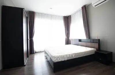 Spacious modern bedroom with large windows and elegant furnishings