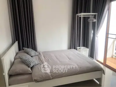 Cozy bedroom with modern decor and balcony access in a stylish apartment.