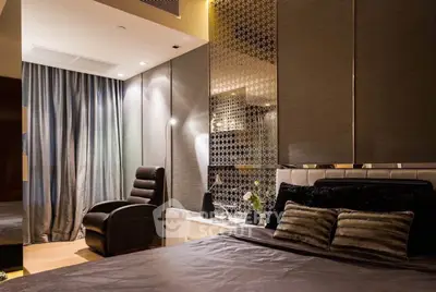 Luxurious bedroom with elegant decor and plush furnishings, featuring a cozy armchair and ambient lighting.
